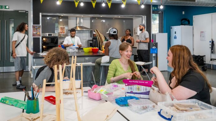 Young people gathered at Forest Road Youth Hub cooking, making bracelets and chatting with each other.