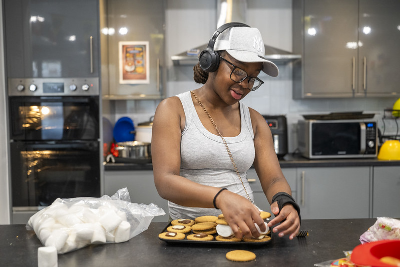 A young woman making smores at Forest Road Youth Hub
