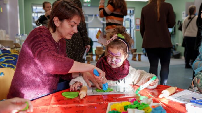 A mother and daughter using arts and crafts at a table