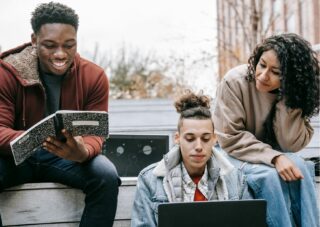 3 young people sat looking at laptops